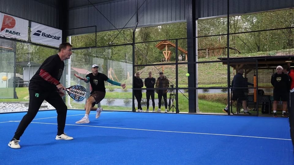 Hráči a diváci na krytém padelovém kurtu Padelun